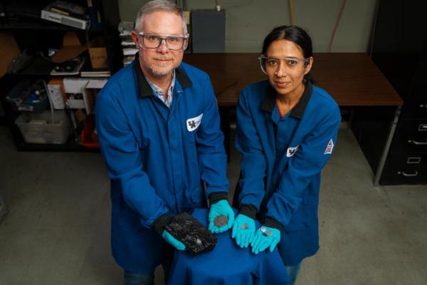 Matt Weisenberger and Aman Preet Kaur hold the progression of coal, from raw resource to finished battery.