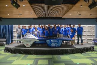 Solar Car Team standing behind the UK solar car.