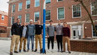 SpaceLex students standing in the Engineering courtyard with a rocket.