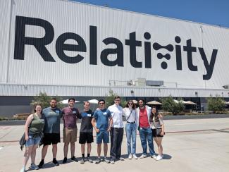 Students in front of a building with Relativity in big letters on it.