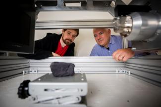 Brent Seales and Seth Parker (Digital Restoration Initiative project lead) scanning a replica of the Herculaneum scroll on the University of Kentucky campus.  Photo Credit: UK Photo.