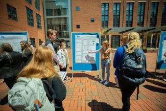 Student presenting research outside. 