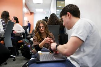 Two students working together with a labtop and medical device prototype