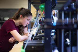 Student working on a 3D printer in the innovation center.