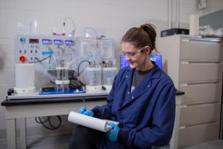 Woman in front of chemical engineering equipment