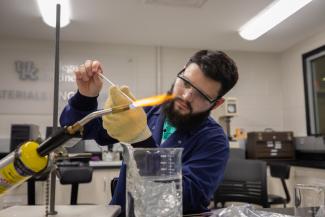 Student in Materials Science Lab with blow torch and melting glass