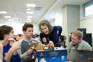 Student working with a professor to create ping pong ball canons.