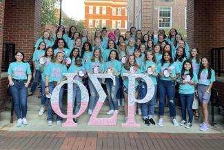 Phi Sigma Rho students all wearing matching t-shirts and standing behind the greek letters.