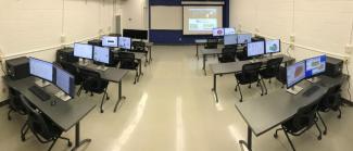 Spark lab, with tables and computers and a projector at the front of the room.