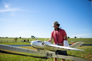 Student with research drone on airfeild