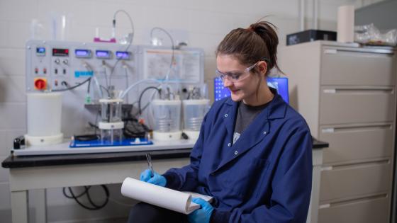 Woman in front of chemical engineering equipment