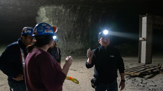 3 students in a mine looking around.