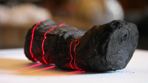 Herculaneum scroll with red laser lines being scanned at Institut de France by Brent Seales and his team.
