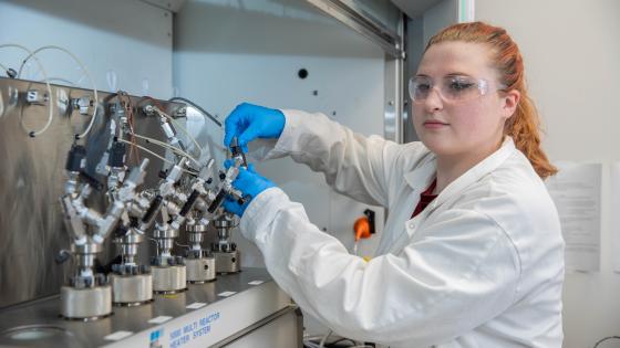 Student in front of chemical engineering equipment