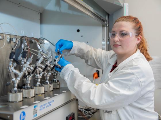 Student in front of chemical engineering equipment