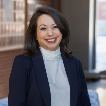 A woman in a blue blazer and white blouse smiling for the camera