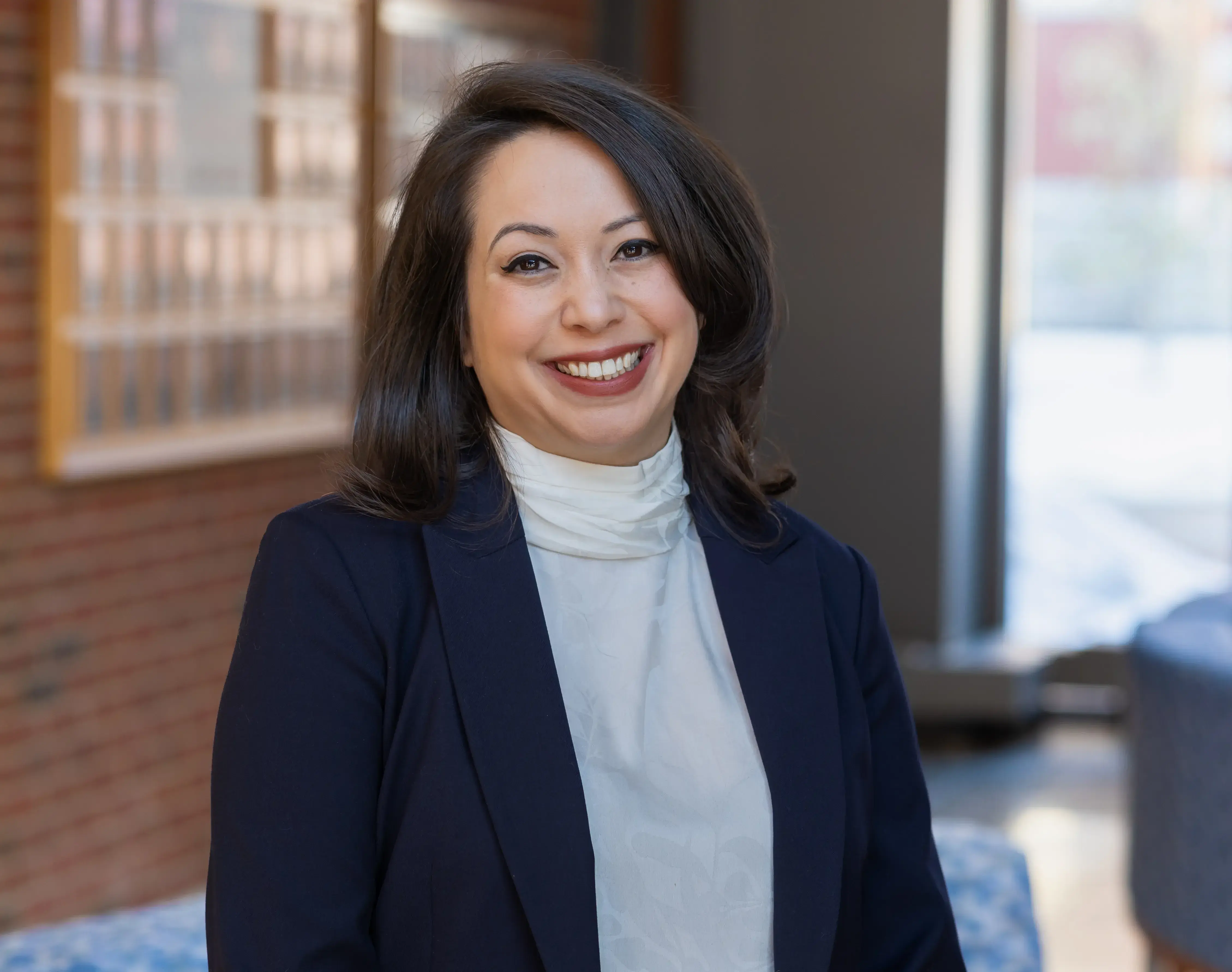 A woman in a blue blazer and white blouse smiling for the camera